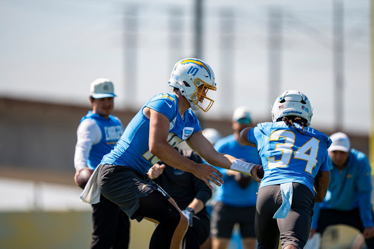 Los Angeles Chargers quarterback Justin Herbert (10) handing the ball off to running back Keaton Mitchell (34) during Chargers training camp at The Bolt on Friday, July 31th in El Segundo, CA. Los Angeles Chargers quarterback Justin Herbert (10) handing the ball off to running back Keaton Mitchell (34) during Chargers training camp at The Bolt on Friday, July 31th in El Segundo, CA.