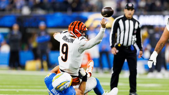 Joe Burrow #9 of the Cincinnati Bengals throws whiles being tackled during the first half against the Los Angeles Chargers at SoFi Stadium on November 17, 2024 in Inglewood, California.