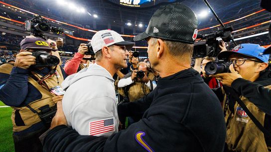 Jim Harbaugh of the Los Angeles Chargers hugs John Harbaugh of the Baltimore Ravens after a game at SoFi Stadium on November 25, 2024 in Inglewood, California.