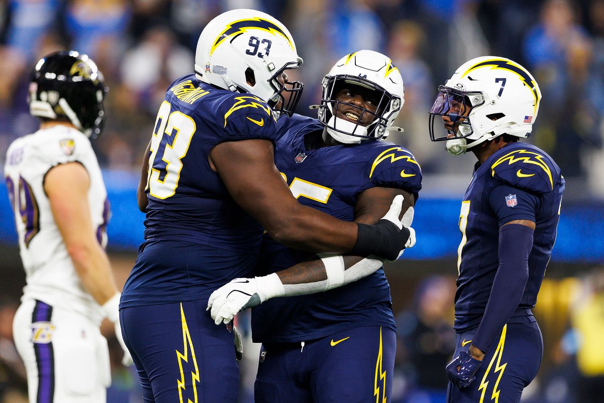 Otito Ogbonnia #93 of the Los Angeles Chargers and Poona Ford #95 of the Los Angeles Chargers celebrates during the first half against the Baltimore Ravens at SoFi Stadium on November 25, 2024 in Inglewood, California. 