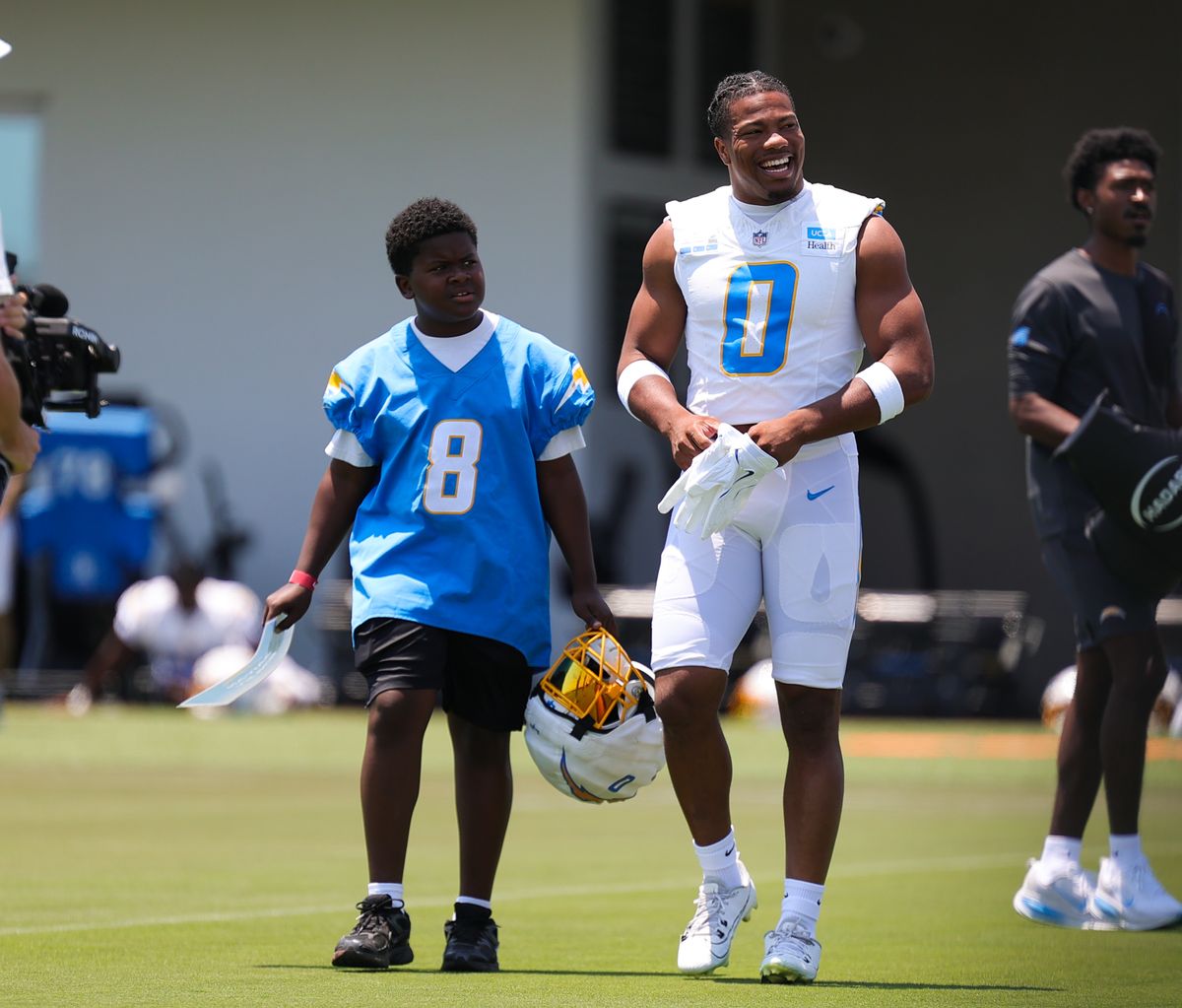 Los Angeles Chargers #0 LB Daiyan Henley walks to the field with a Snoop Youth Football League player during training camp on July 18, 2025 at the Bolt practice facility in El Segundo, CA. Los Angeles Chargers #0 LB Daiyan Henley walks to the field with a Snoop Youth Football League player during training camp on July 18, 2025 at the Bolt practice facility in El Segundo, CA.
