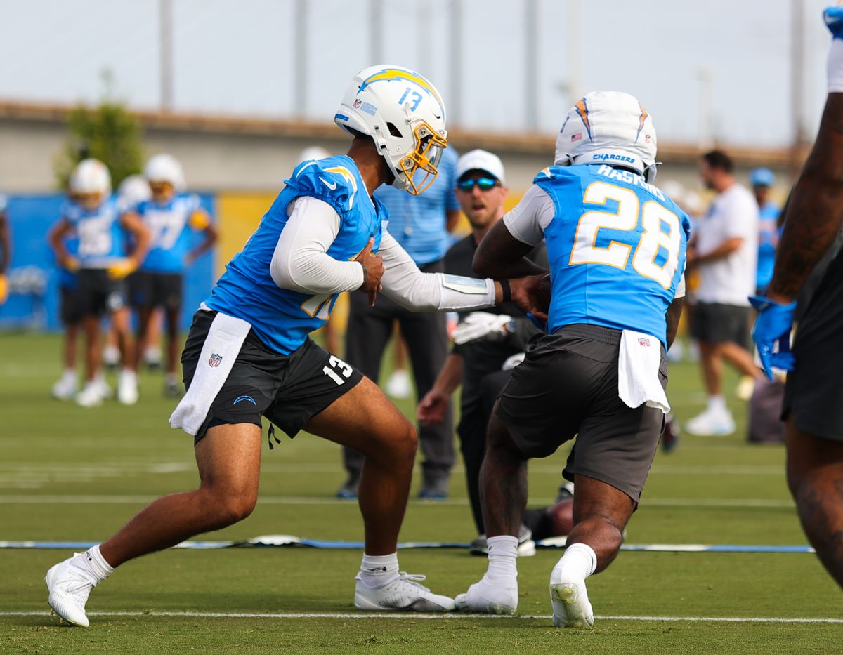 Los Angeles Chargers #13 QB DJ Uiagalelei hands off to #28 RB Hassan Haskins during training camp on July 19, 2025 at the Bolt practice facility in El Segundo, CA. Los Angeles Chargers #13 QB DJ Uiagalelei hands off to #28 RB Hassan Haskins during training camp on July 19, 2025 at the Bolt practice facility in El Segundo, CA.