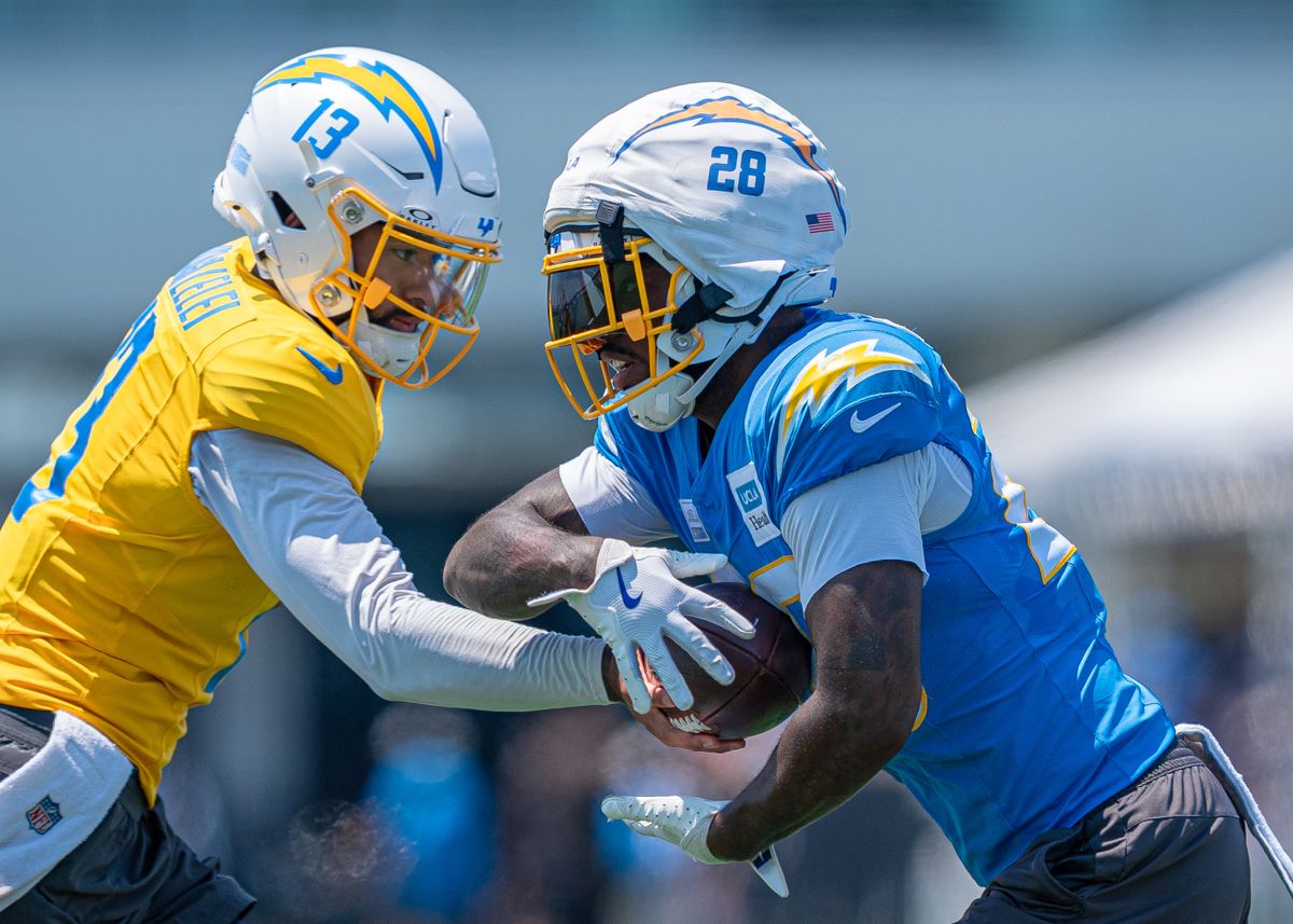 Los Angeles Chargers' running back, Hassan Haskins 28, receives a hand-off from quarterback DJ Uiagalelei (13) during practice at the Chargers' NFL training camp on Sunday, August 3, 2025 at The Bolt in El Segundo, CA. Los Angeles Chargers' running back, Hassan Haskins 28, receives a hand-off from quarterback DJ Uiagalelei (13) during practice at the Chargers' NFL training camp on Sunday, August 3, 2025 at The Bolt in El Segundo, CA.
