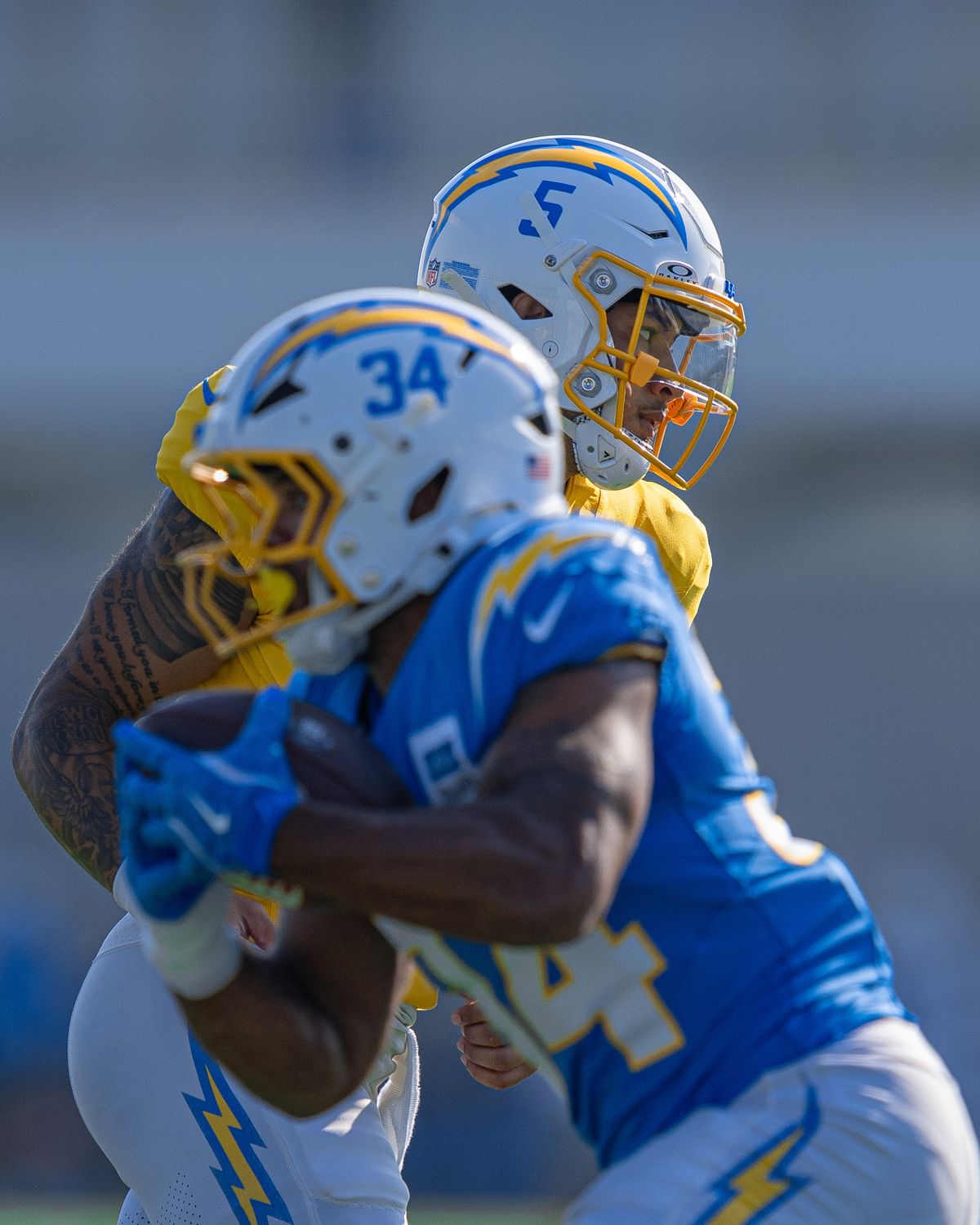 Los Angeles Chargers' quarterback, Trey Lance 5, tosses the ball to running back Jaret Patterson (34) during practice at The Bolt on Tuesday, August 5th, 2025 in El Segundo, CA.