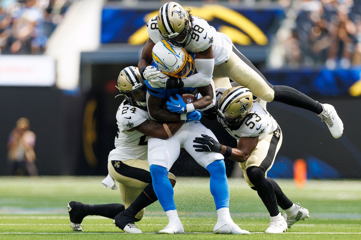 Hassan Haskins #28 of the Los Angeles Chargers is tackled during the second half against the New Orleans Saints at SoFi Stadium on August 10, 2025 in Inglewood, California. 