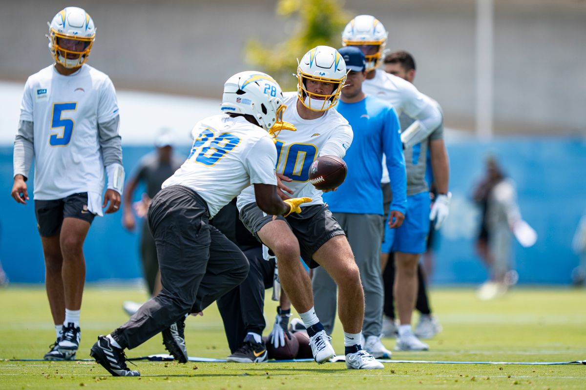 Los Angeles Chargers quarterback Justin Herbert (10) hands the ball off to running back Kimani Vidal (28) during Chargers organized team activities at the Bolt on Tuesday, June 2nd in El Segundo, CA. Los Angeles Chargers quarterback Justin Herbert (10) hands the ball off to running back Kimani Vidal (28) during Chargers organized team activities at the Bolt on Tuesday, June 2nd in El Segundo, CA.