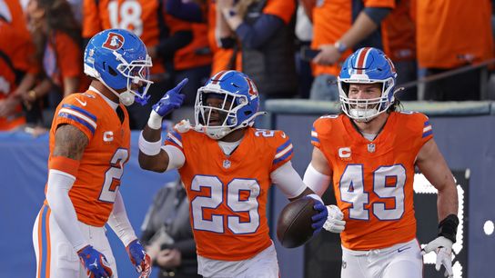 Jan 4, 2026; Denver, Colorado, USA; Denver Broncos cornerback Ja'quan McMillian (29) celebrates with teammates after scoring a touchdown against the Los Angeles Chargers during the first half at Empower Field at Mile High.