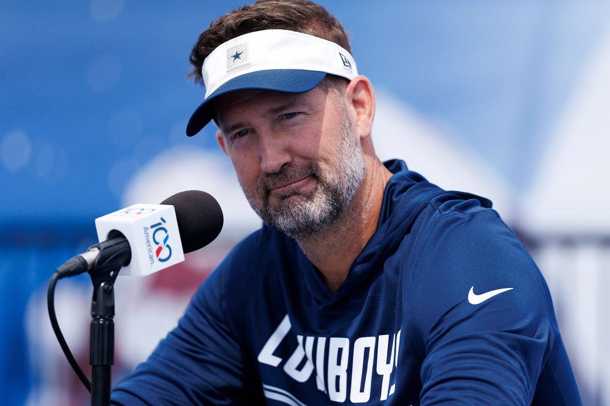 Brian Schottenheimer of the Dallas Cowboys speaks with members of the media during training camp at River Ridge Playing Fields on July 30, 2026 in Oxnard, California.