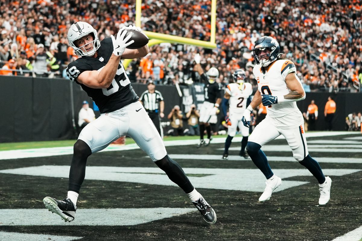 Raiders tight end Brock Bowers (89) makes a successful catch ahead of Broncos safety Talanoa Hufanga (9), scoring a touchdown in first quarter of NFL game against the Broncos Sunday, Dec. 7, 2025 at Allegiant Stadium in Las Vegas.  