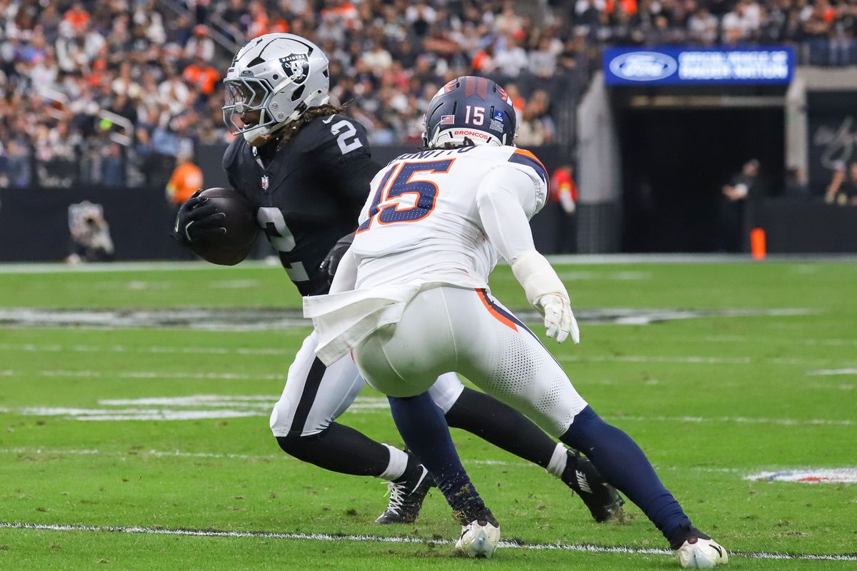 Raiders running back Ashton Jeanty (2) attempts to escape Broncos linebacker Nik Bonitto (15) during first quarter of NFL game against the Broncos on Sunday, Dec. 7, 2025 at Allegiant Stadium in Las Vegas.