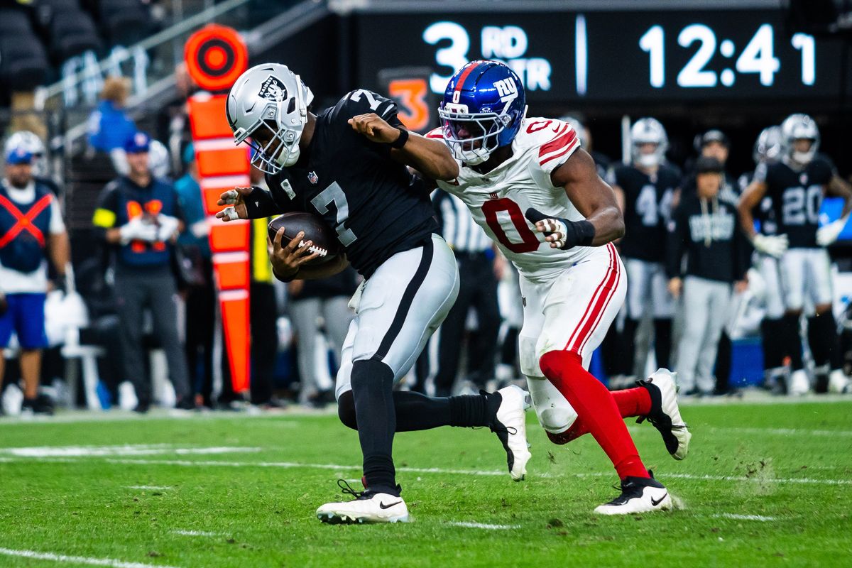 Las Vegas Raiders quarterback Geno Smith (7) is sacked by New York Giants linebacker Brian Burns (0) during a NFL game between the Las Vegas Raiders and the New York Giants, Sunday December 28, 2025 in Las Vegas, Nev.