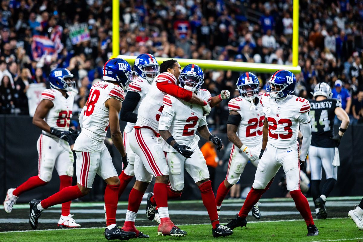 New York Giants celebrate and embrace cornerback Deonte Banks (2) after Banks returns a kick-off for a touchdown during a NFL game between the Las Vegas Raiders and the New York Giants, Sunday December 28, 2025 in Las Vegas, Nev.