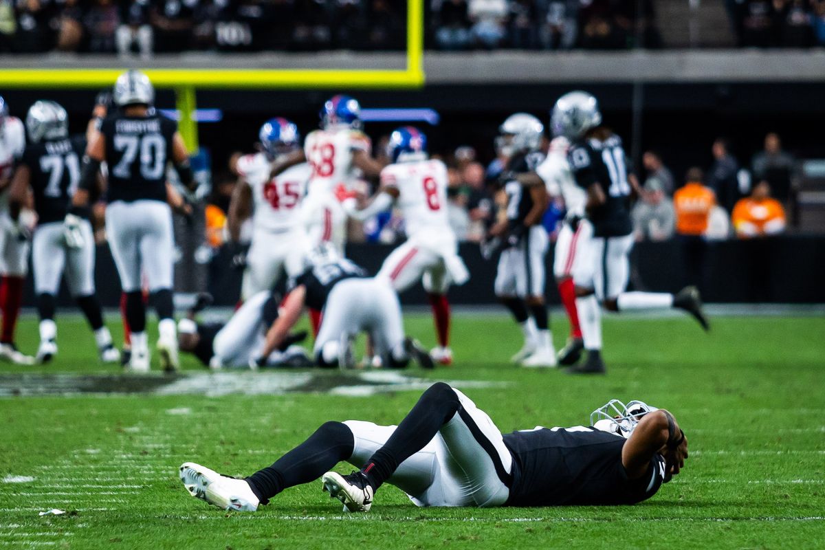 Las Vegas Raider quarterback Geno Smith (7) puts his hands over his head while on the ground after throwing an interception during a NFL game between the Las Vegas Raiders and the New York Giants, Sunday December 28, 2025 in Las Vegas, Nev.