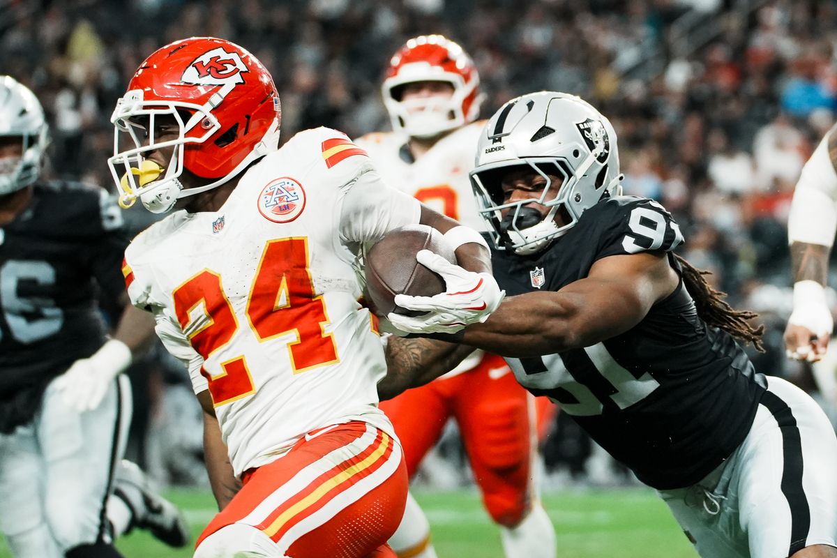 Chiefs running back Brassard Smith (24) tries to escape Raiders defensive end Jahfari Harvey (91) during second half of NFL game against Raiders on Sunday, January 4, 2026 at Allegiant Stadium in Las Vegas.