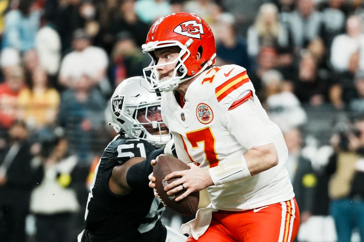 Chiefs quarterback Shane Buechele (17) scans the field while Raiders defensive end Malcolm Koonce (51) reaches to tackle him during second half of NFL game against Raiders on Sunday, January 4, 2026 at Allegiant Stadium in Las Vegas.
