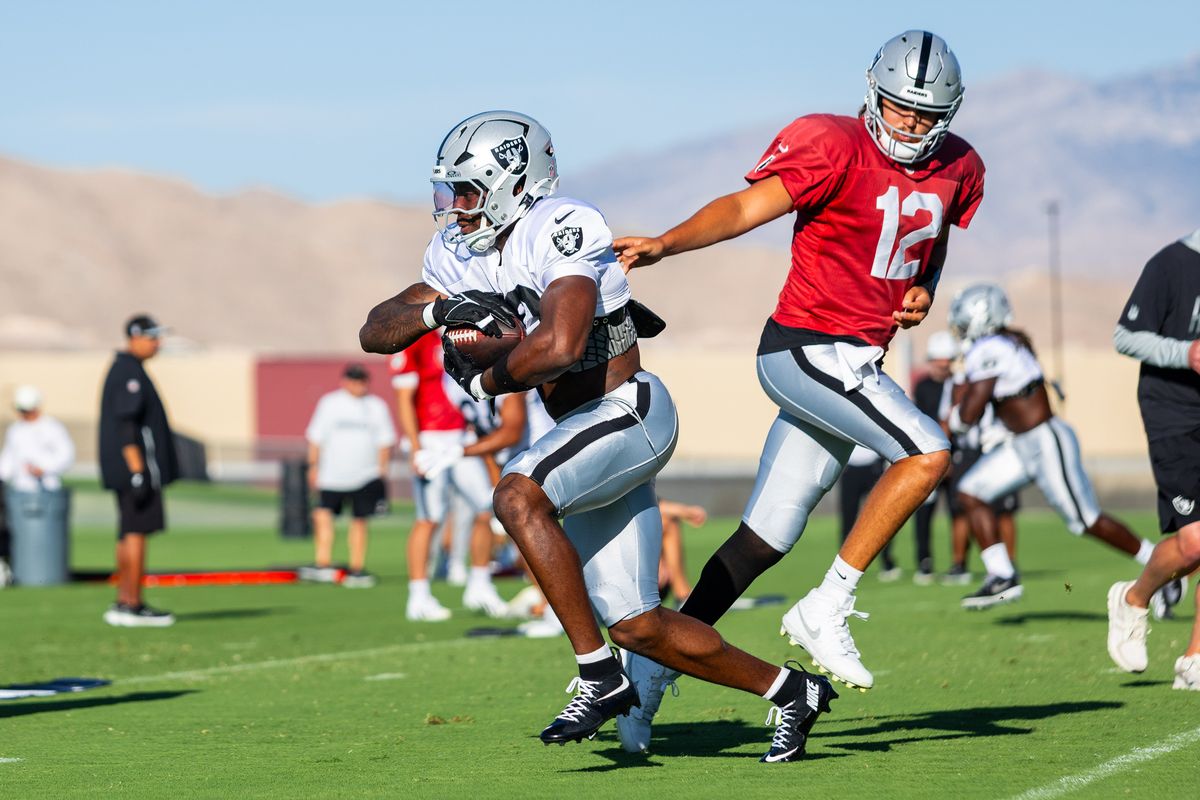 Las Vegas Raiders quarterback Aidan O’Connell (12) hands the ball off to running back Mike Washington Jr. (30) during Raiders Training Camp at Intermountain Health Performance Center, Monday August 17, 2026 in Henderson, Nev.