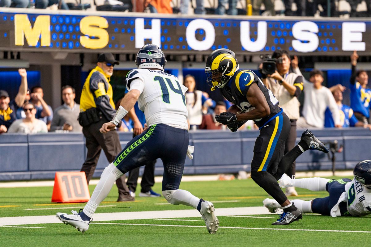 Seattle Seahawks quarterback, Sam Darnold (14) attempts to tackle a defender after throwing an interception during an NFL football game against the Los Angeles Rams on November 16, 2025 in Los Angeles, CA.