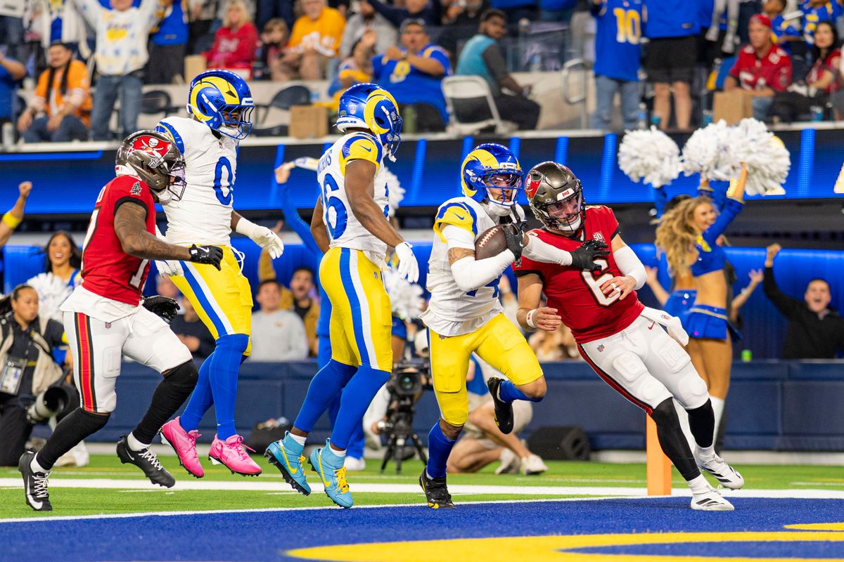 Los Angeles Rams cornerback, Cobie Durant (14) returns an interception for a touchdown while pushing away Baker Mayfield (6) during an NFL football game against the Tampa Bay Buccaneers on November 23, 2025 in Los Angeles, CA.