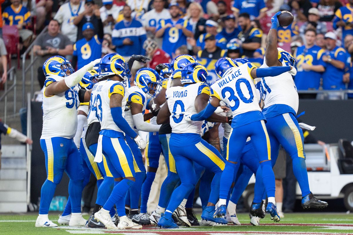 Los Angeles Rams defenders celebrate an interception during an NFL football game against the Arizona Cardinals on Sunday, Dec. 7, 2025, in Glendale, AZ.
