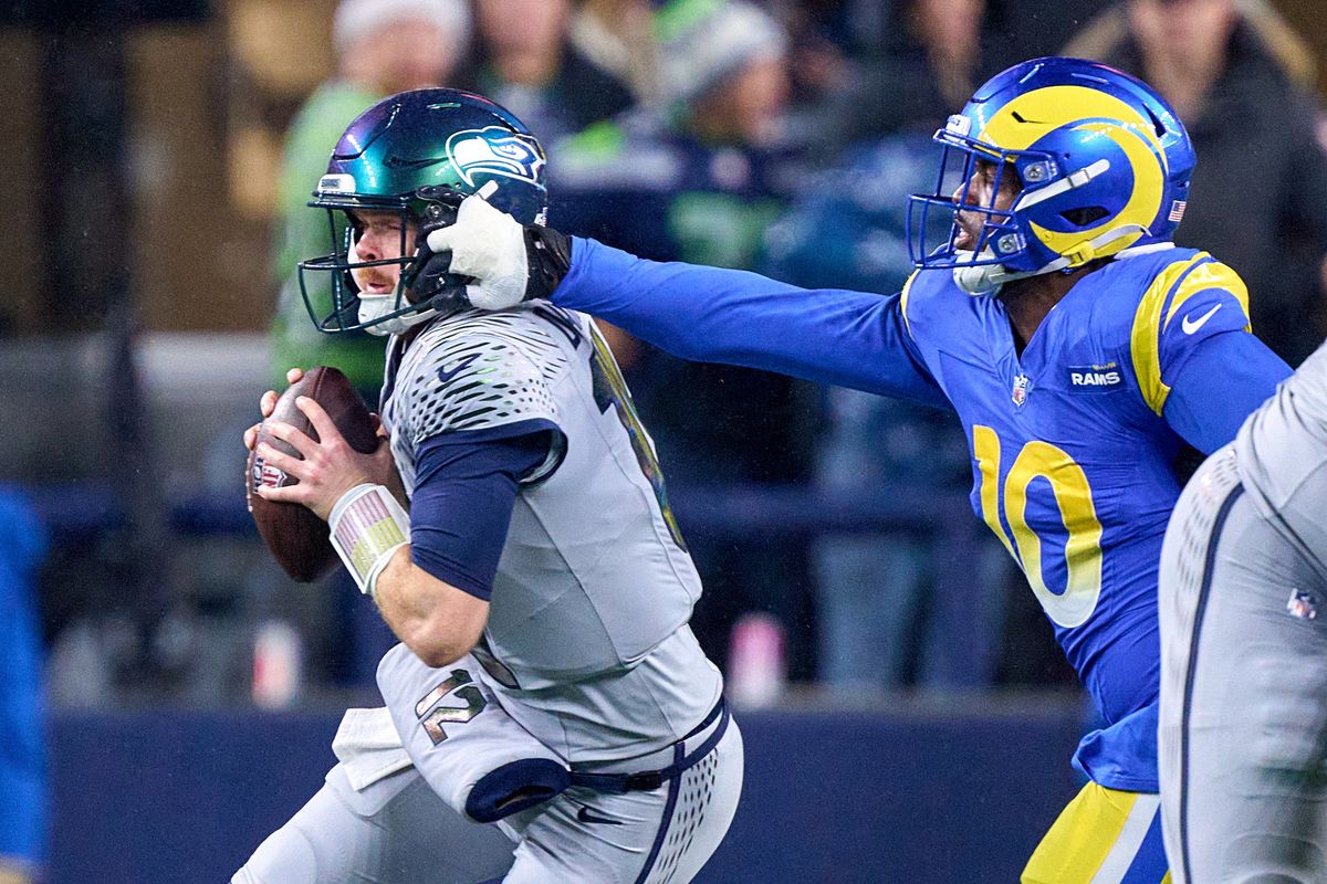 Seattle Seahawks quarterback Sam Darnold (14) battles with Los Angeles Rams linebacker Josaiah Stewart (10) during an NFL football game against the Los Angeles Rams, on Thursday December 18, 2025 in Seattle, Washington.
