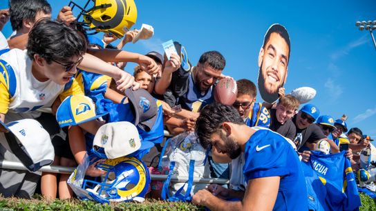 Los Angeles Rams wide receiver Puka Nacua (12) signing merchandise for fans during Rams training camp at the Loyola Marymount University on Monday, July 27th in Westchester, CA.