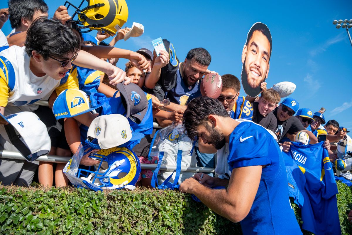 Los Angeles Rams wide receiver Puka Nacua (12) signing merchandise for fans during Rams training camp at the Loyola Marymount University on Monday, July 27th in Westchester, CA.