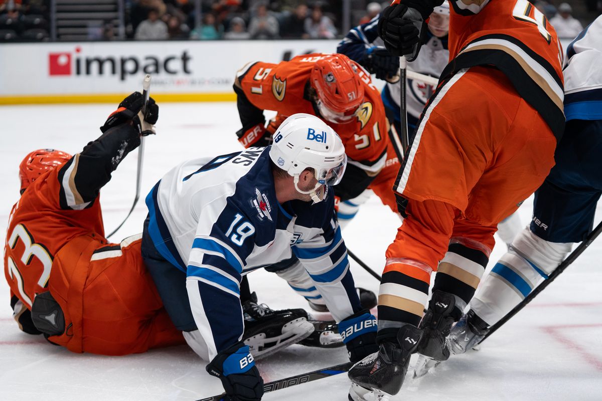 Anaheim Ducks players scramble on the ice to get the puck during an NHL hockey game against the Winnipeg Jets, Sunday November 9, 2025 in Anaheim, Calif.