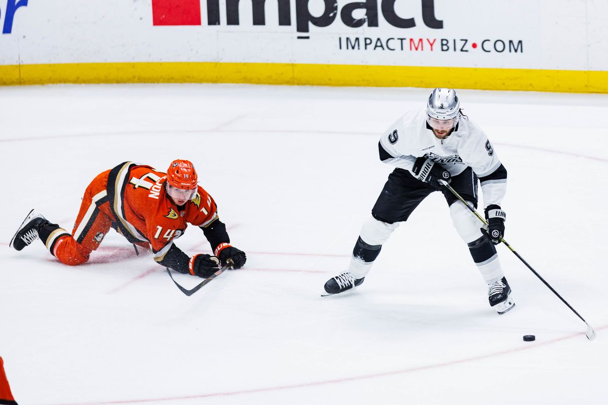 Los Angeles Kings right wing Adrian Kempe (9) defends the puck from Anaheim Ducks defense Drew Helleson (14) during an NHL game against the Anaheim Ducks on November 28, 2025 in Anaheim, Calif.