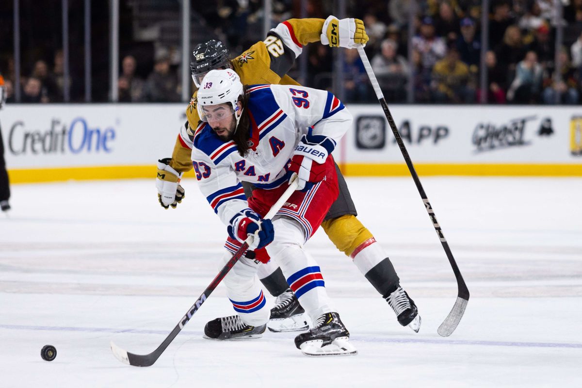 New York Rangers center Mika Zibanejad (93) skates the puck into the offensive zone while being trailed by Vegas Golden Knights right wing Alexander Holtz (26) during a NHL game between the Las Vegas Golden Knights and the New York Rangers, Saturday January 11, 2025 in Las Vegas, Nev.
