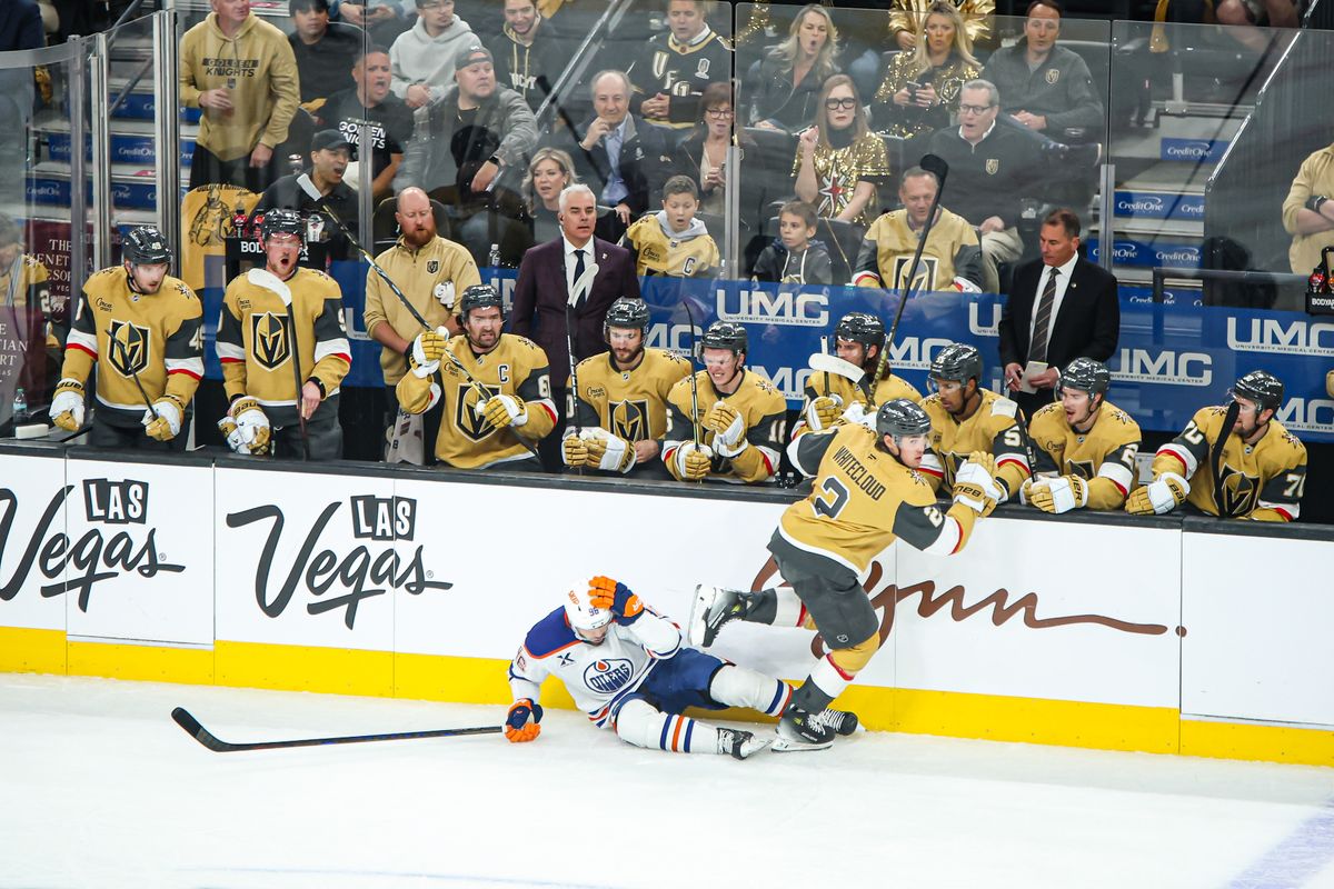 Vegas Golden Knights D Zach Whitecloud (2) hits Edmonton Oilers D Jake Walman (96) in front of the Vegas bench during the first period of an NHL game on Tuesday April 01, 2025 at T-Mobile Arena in Las Vegas, Nevada. 