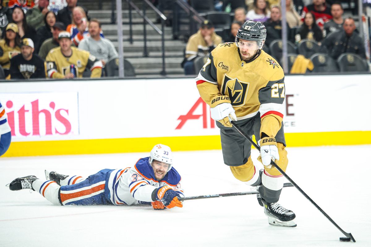 Vegas Golden Knights D Shea Theodore (27) skates the puck around a diving Edmonton Oilers LW Viktor Arvidsson (33) during the third period of an NHL game on Tuesday April 01, 2025 at T-Mobile Arena in Las Vegas, Nevada. 