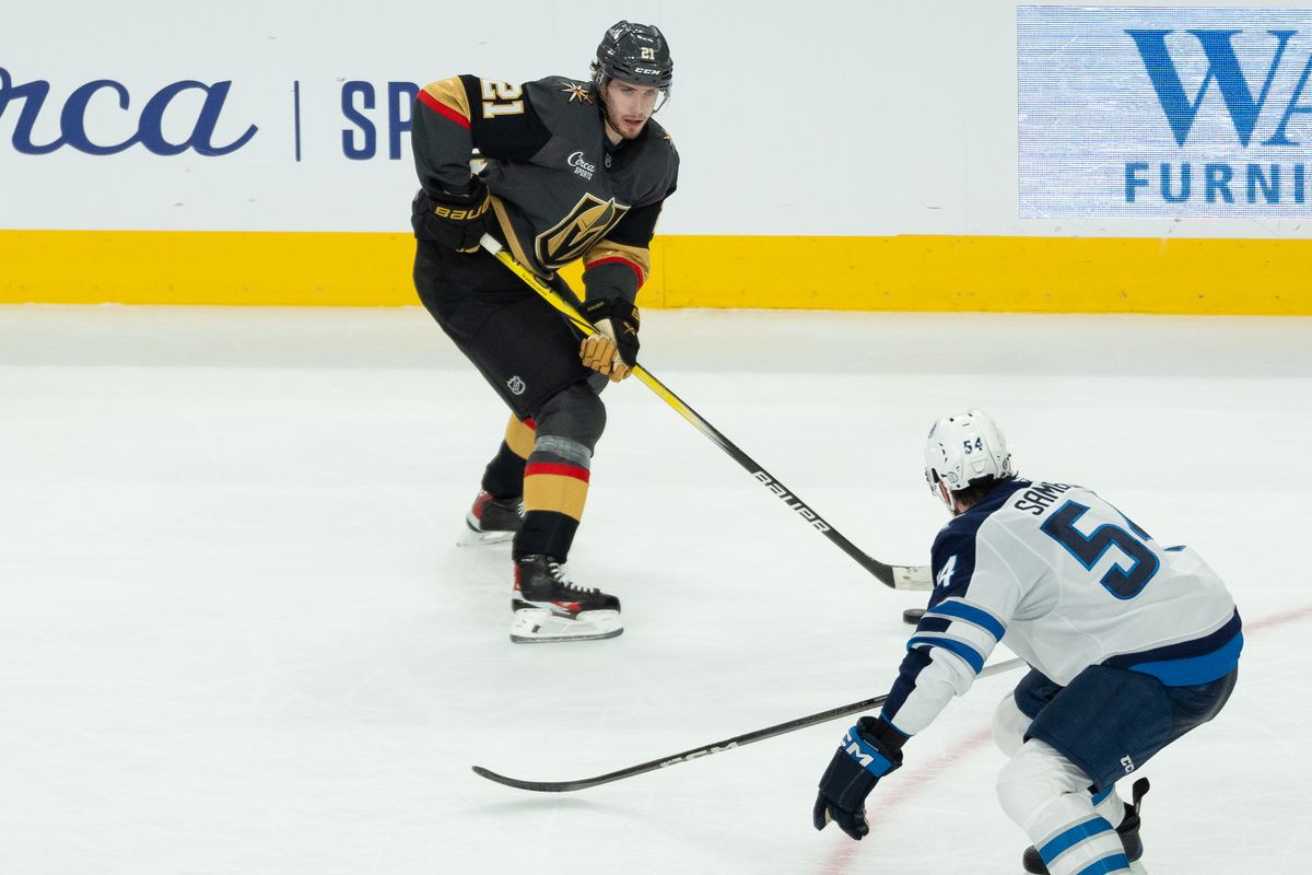 Vegas Golden Knights center Brett Howden (21) scans the ice while blocked by Winnipeg Jets defenseman Dylan Samberg (54) during second period of NHL game against Winnipeg Jets on Thursday April 3, 2025 in Las Vegas.  