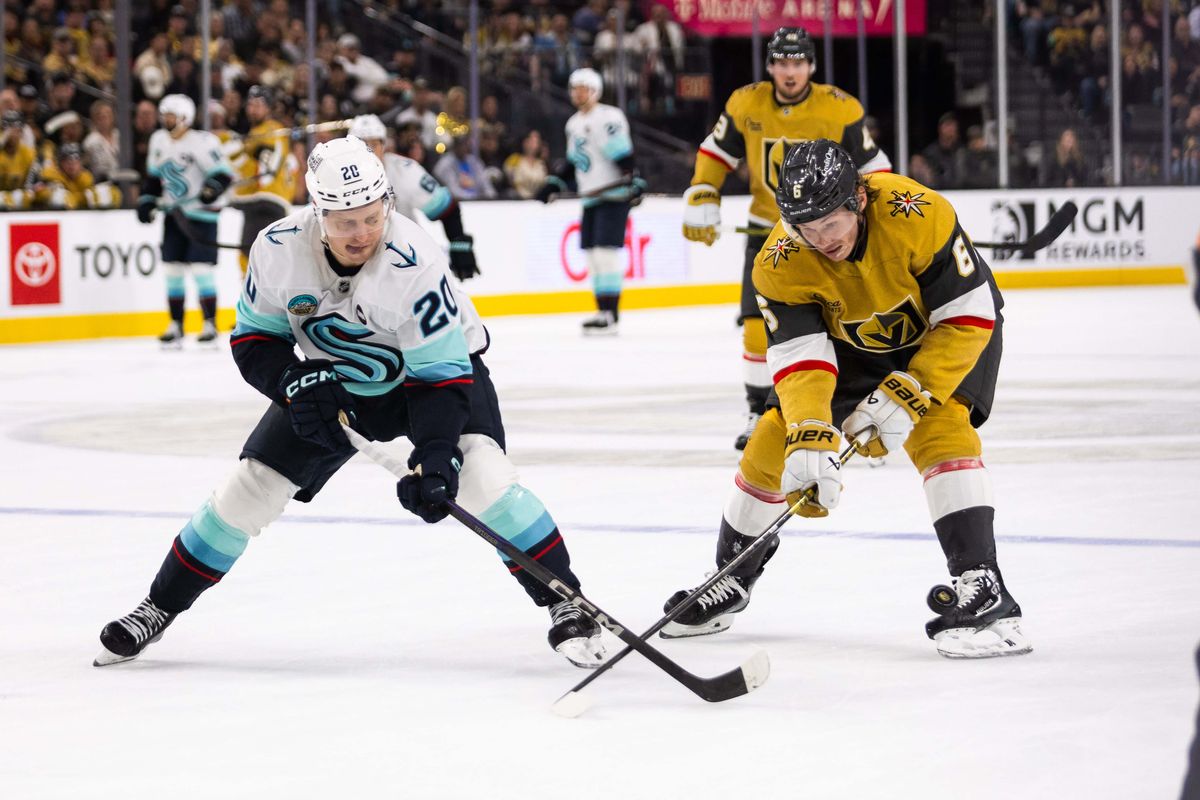 Las Vegas Golden Knights defenseman Kaedan Korczak (6) and Seattle Kraken right-wing Eeli Tovanen (20) battle for a loose puck during a NHL game between the Las Vegas Golden Knights and the Seattle Kraken, Thursday April 10, 2025 in Las Vegas, Nev.