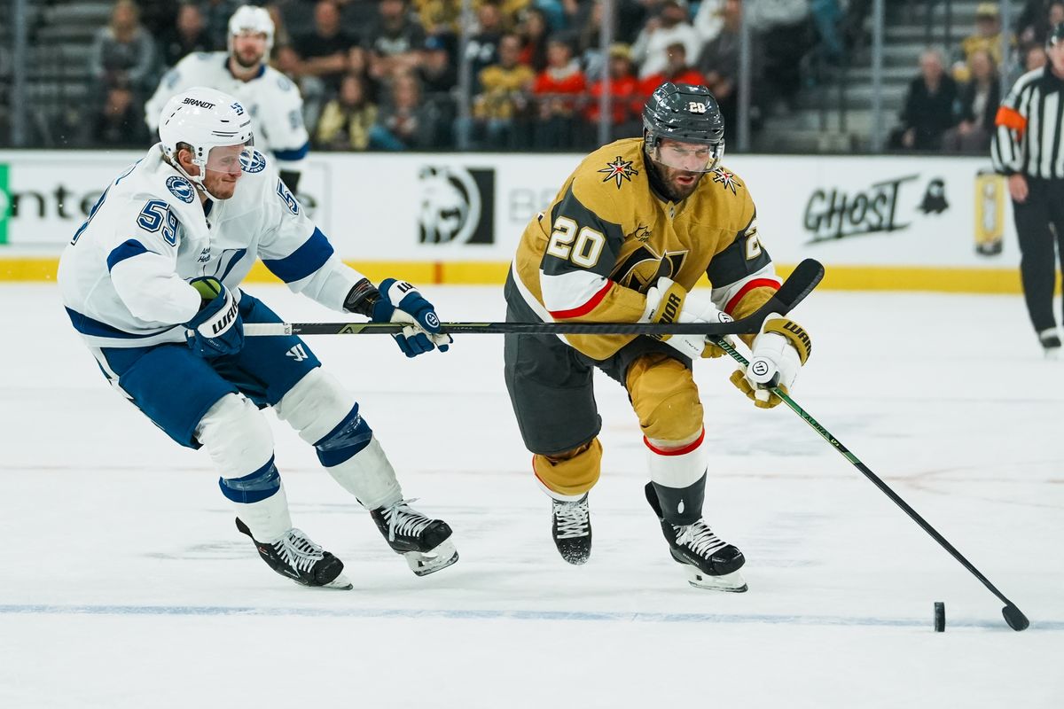 Vegas Golden Knights left wing Brandon Saad (20) and Tampa Bay Lightning center Jake Guentzel (59) race to the puck during first period of NHL game against Tampa Bay Lightning on Tuesday, Nov. 6, 2025 at T-Mobile Arena in Las Vegas.