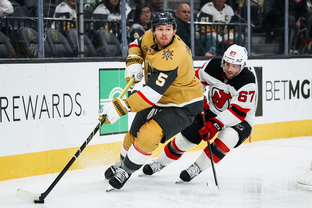 Vegas Golden Knights defensemen Jeremy Lauzon (5) skates the puck around the goal, trying to escape Devils lcenter Xavier Parent during third period of NHL game against New Jersey Devils on Wed., Dec. 17, 2025, at T-Mobile Arena in Las Vegas.