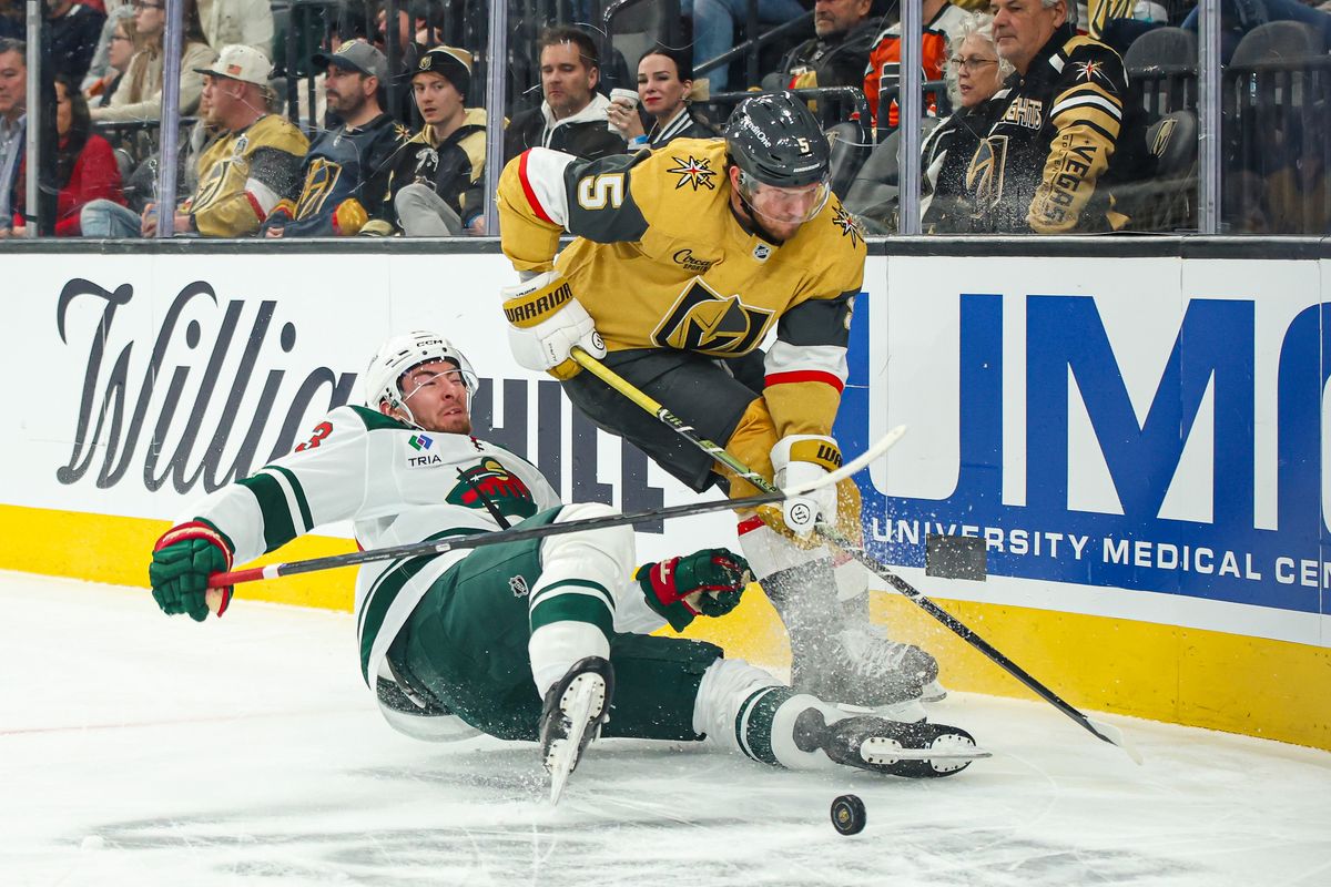 Vegas Golden Knights D Jeremy Lauzon (5) plays the puck over a falling Minnesota Wild skater during an NHL game on Monday December 29, 2025, in Las Vegas, Nevada. 