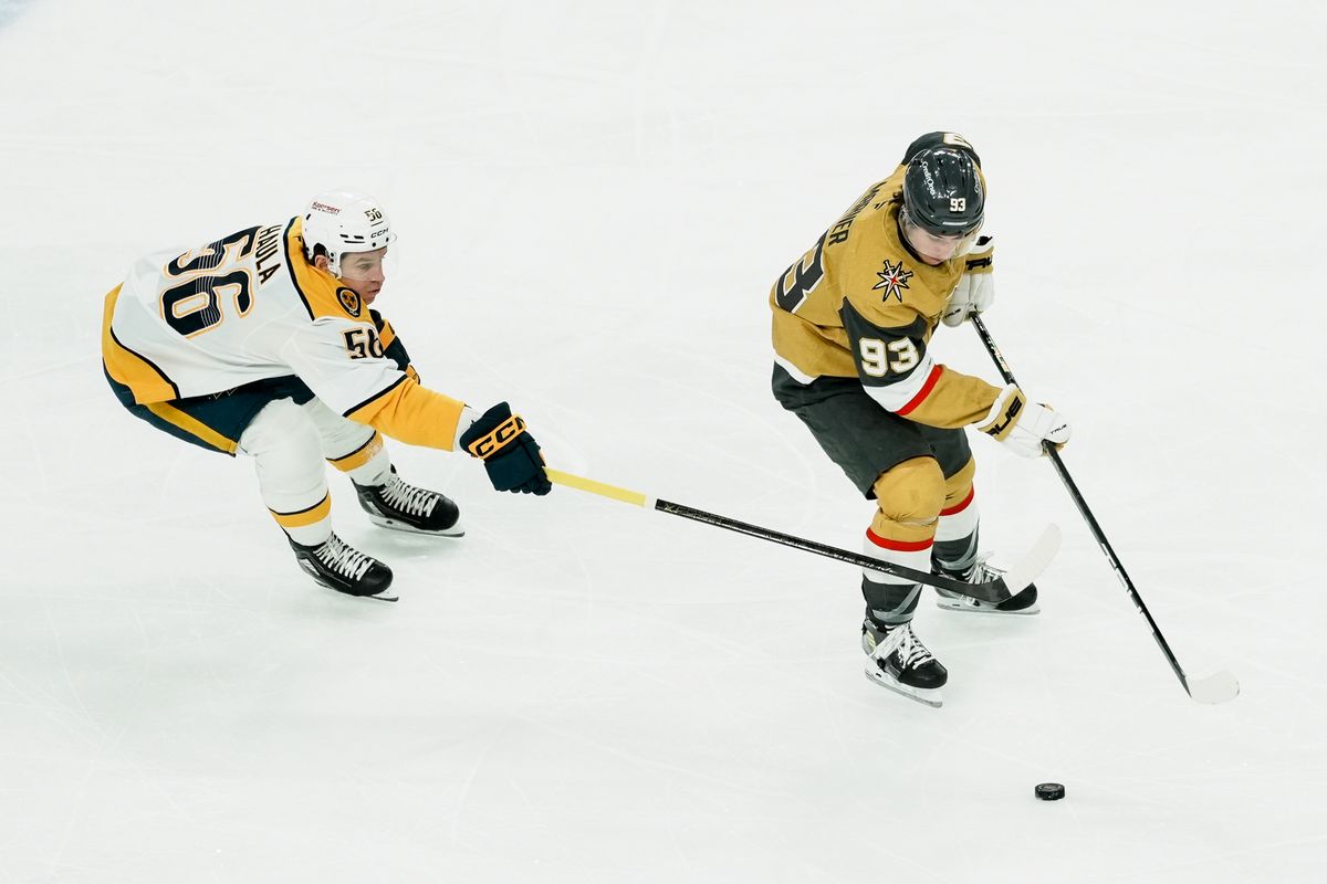 Nashville Predators left wing Erik Haula (58) reached to take the puck from Golden Knights right wing Mitch Marner (93) during first period of NHL game against Vegas Golden Knights on Saturday Jan. 17, 2026 at T-Mobile Arena in Las Vegas.