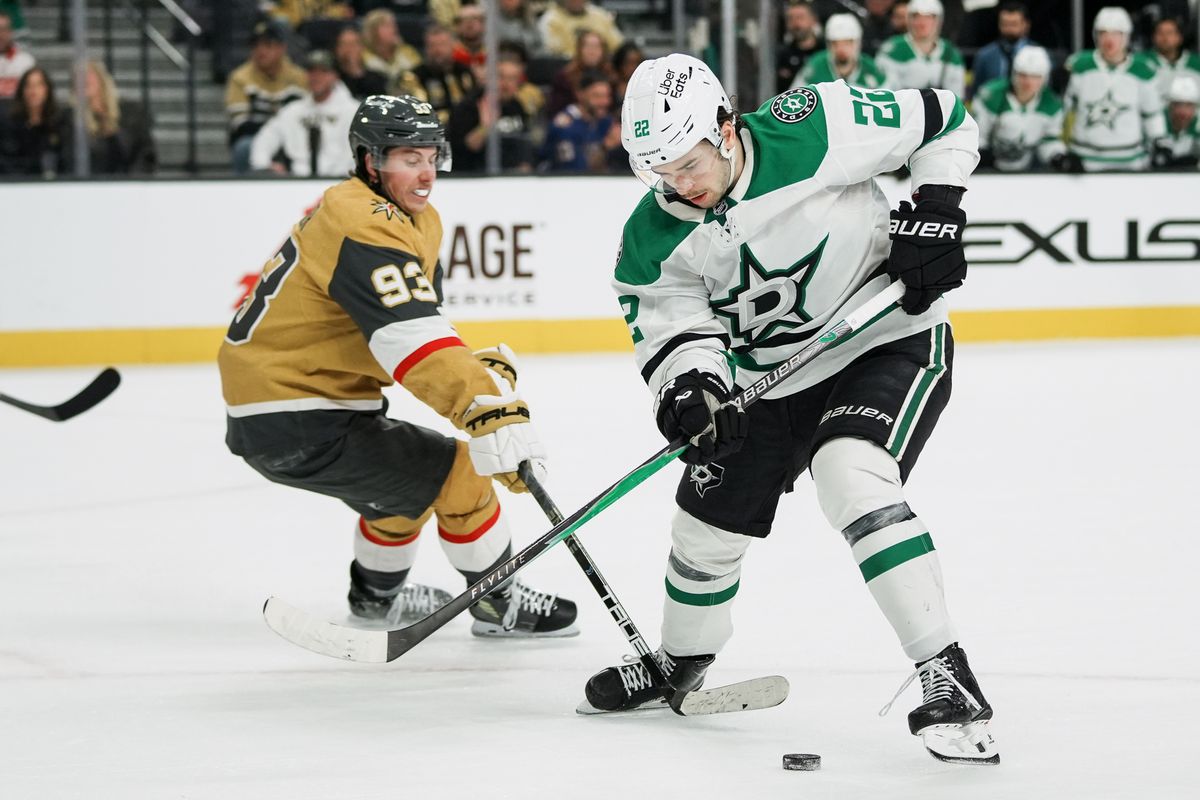 Dallas Stars center Mavrik Bourgque (22) scans down at the puck while Golden Knights right wing Mitch Marner (93) reaches for it  during overtime of NHL game against Vegas Golden Knights on Thursday Jan. 29, 2026 at T-Mobile Arena in Las Vegas.