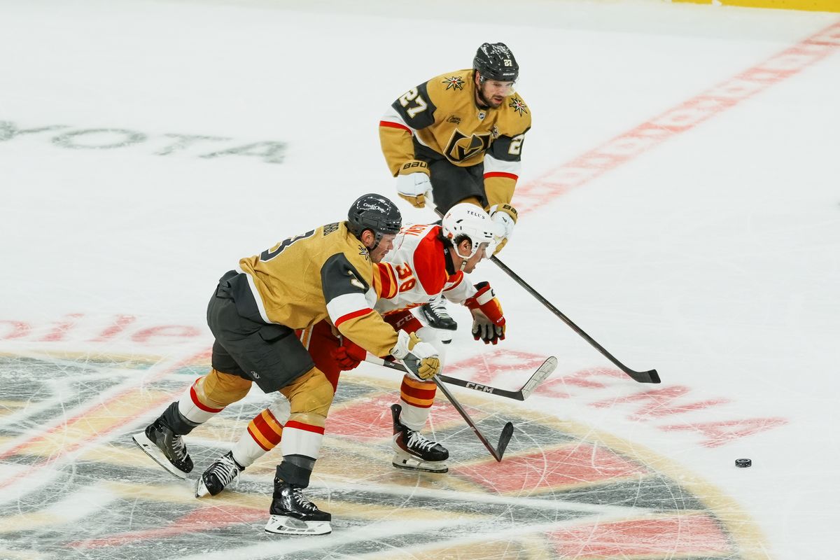 Vegas Golden Knights defenseman Brayden McNabb (3) and Shea Theodore (27) race Calgary Flames center Jonathan Castanga (38) tothe puck during first period of NHL game against Calgary Flames on Thursday October 15, 2026 at T-Mobile Arena in Las Vegas. Vegas Golden Knights defenseman Brayden McNabb (3) and Shea Theodore (27) race Calgary Flames center Jonathan Castanga (38) tothe puck during first period of NHL game against Calgary Flames on Thursday October 15, 2026 at T-Mobile Arena in Las Vegas.