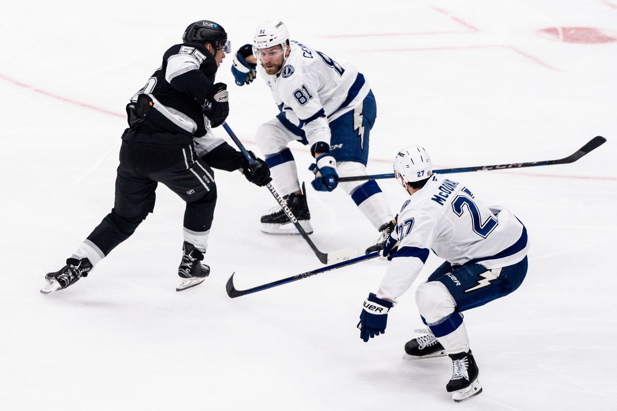 Los Angeles Kings player shoots between two defenders trying to score a goal in a game against the Tampa Bay Lightning on January 4, 2025 at Crypto.com Arena