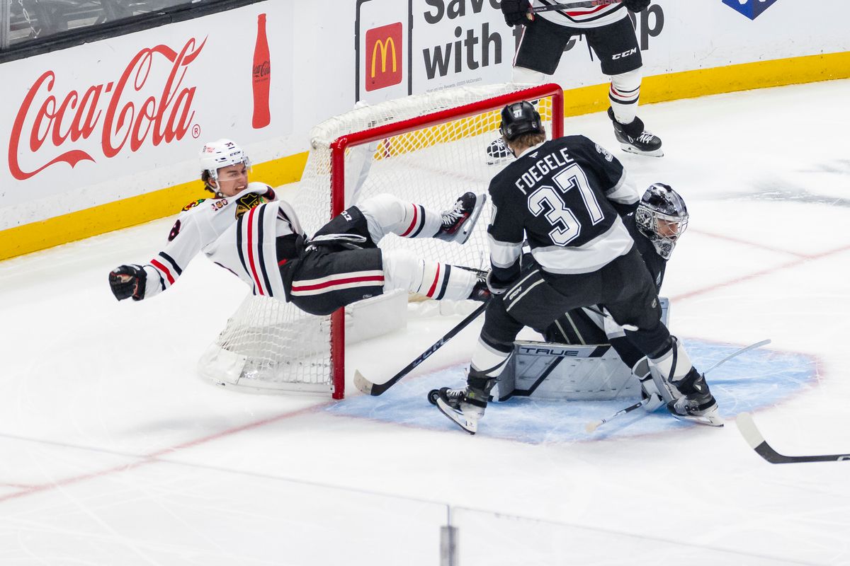 Center Connor Bedard #98 of the Chicago Blackhawks gets tripped as the puck slips past goaltender Darcy Kuemper #35 of the Los Angeles Kings for a goal during an NHL hockey game, Thursday December 4, 2025 in Los Angeles, Calif.