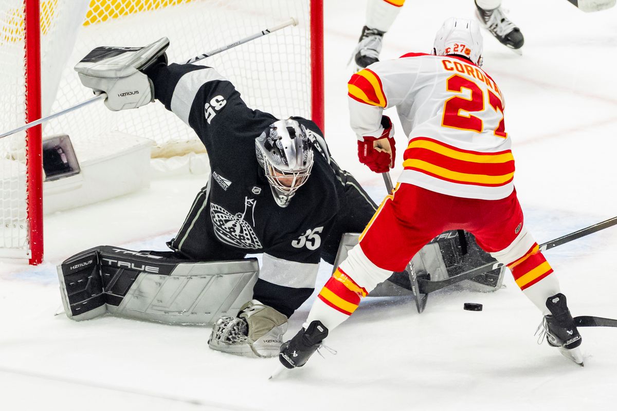 Goaltender Darcy Kuemper #35 of the Los Angeles Kings makes a save against right wing Matt Coronato #27 of the Calgary Flames during an NHL hockey game, Saturday December 13, 2025 in Los Angeles, Calif.