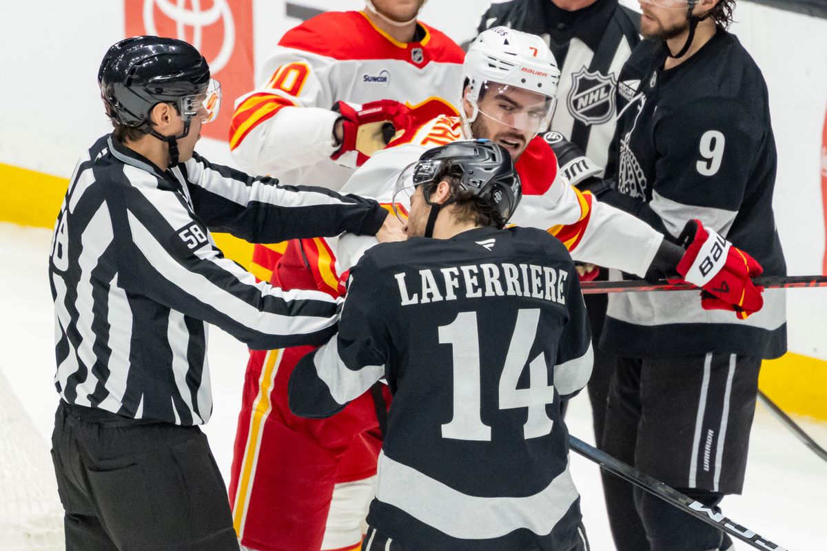 Right wing Alex Laferriere #14 of the Los Angeles Kings takes a punch from defenseman Kevin Bahl #7 of the Calgary Flames during an NHL hockey game, Saturday December 13, 2025 in Los Angeles, Calif.