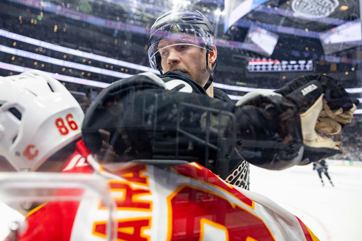 Right wing Joel Armia #40 of the Los Angeles Kings checks left wing Joel Farabee #86 of the Calgary Flames into the boards during an NHL hockey game, Saturday December 13, 2025 in Los Angeles, Calif.