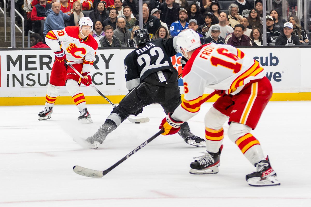 Left wing Jonathan Huberdeau #10 of the Calgary Flames lines up a pass with center Morgan Frost #16 of the Calgary Flames that lead to the overtime game-winning goal during an NHL hockey game against the Los Angeles Kings, Saturday December 13, 2025 in Los Angeles, Calif.