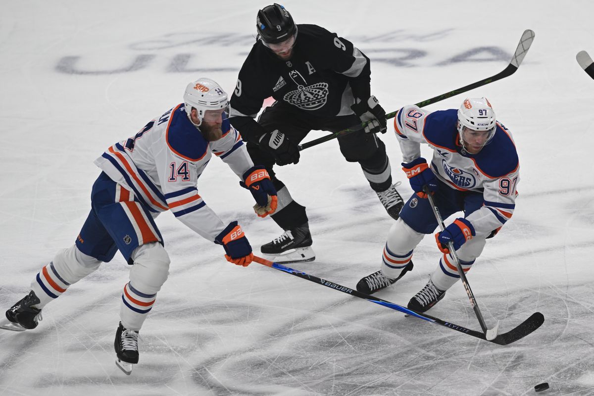 LA Kings right wing Adrian Kempe (9) battles for possession against Edmonton Oilers defense Mattias Ekholm (14) and center Connor McDavid (97) during an NHL game between the Edmonton Oilers and the Los Angeles Kings on Saturday, April 11, 2026 at Crypto.com Arena in Los Angeles Calif