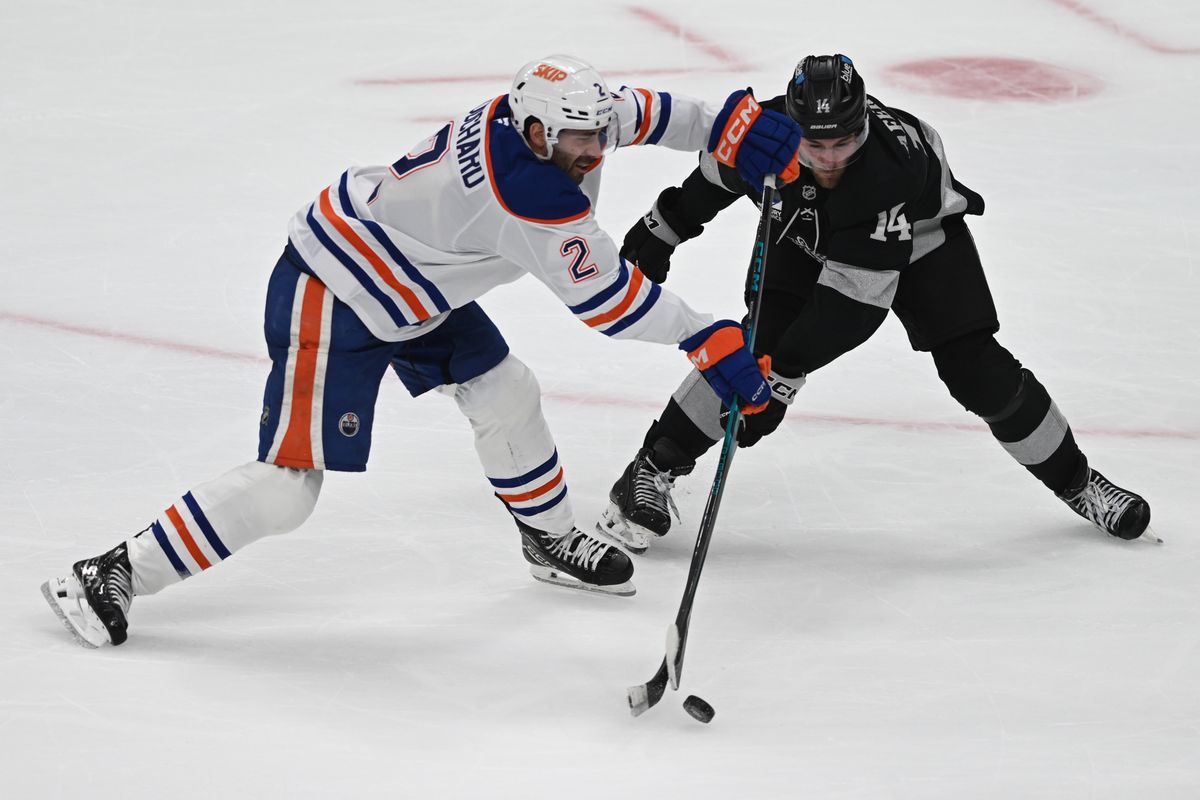 Edmonton Oilers defense Evan Bouchard (2) and LA Kings right wing Alex Laferriere (14) fight for possession during an NHL game between the Edmonton Oilers and the Los Angeles Kings on Saturday, April 11, 2026 at Crypto.com Arena in Los Angeles Calif