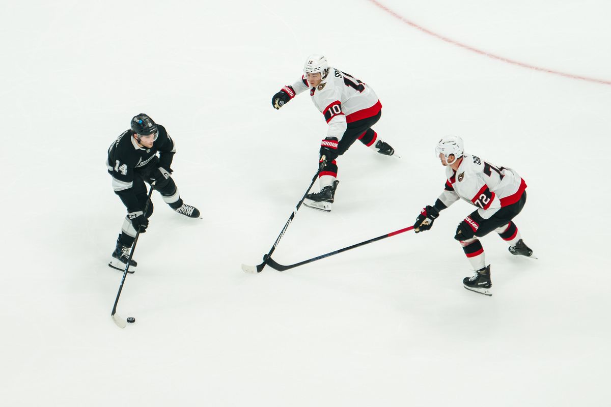 Los Angeles Kings right wing Alex Laferriere (14) keeps the puck away from Ottawa Senators defenders during a game on October 29, 2026, at Crypto.com Arena in Los Angeles, California.