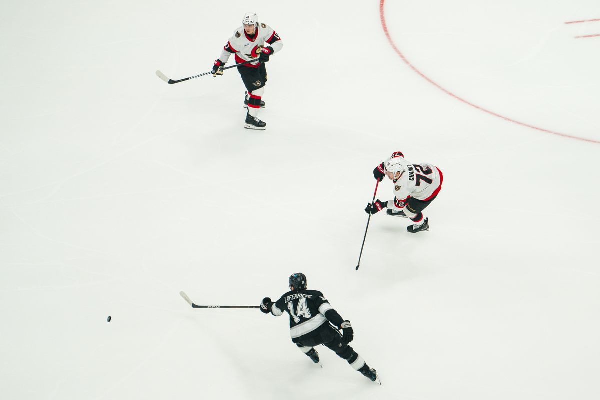 Los Angeles Kings right wing Alex Laferriere (14) keeps the puck away from Ottawa Senators defenders during a game on October 29, 2026, at Crypto.com Arena in Los Angeles, California.