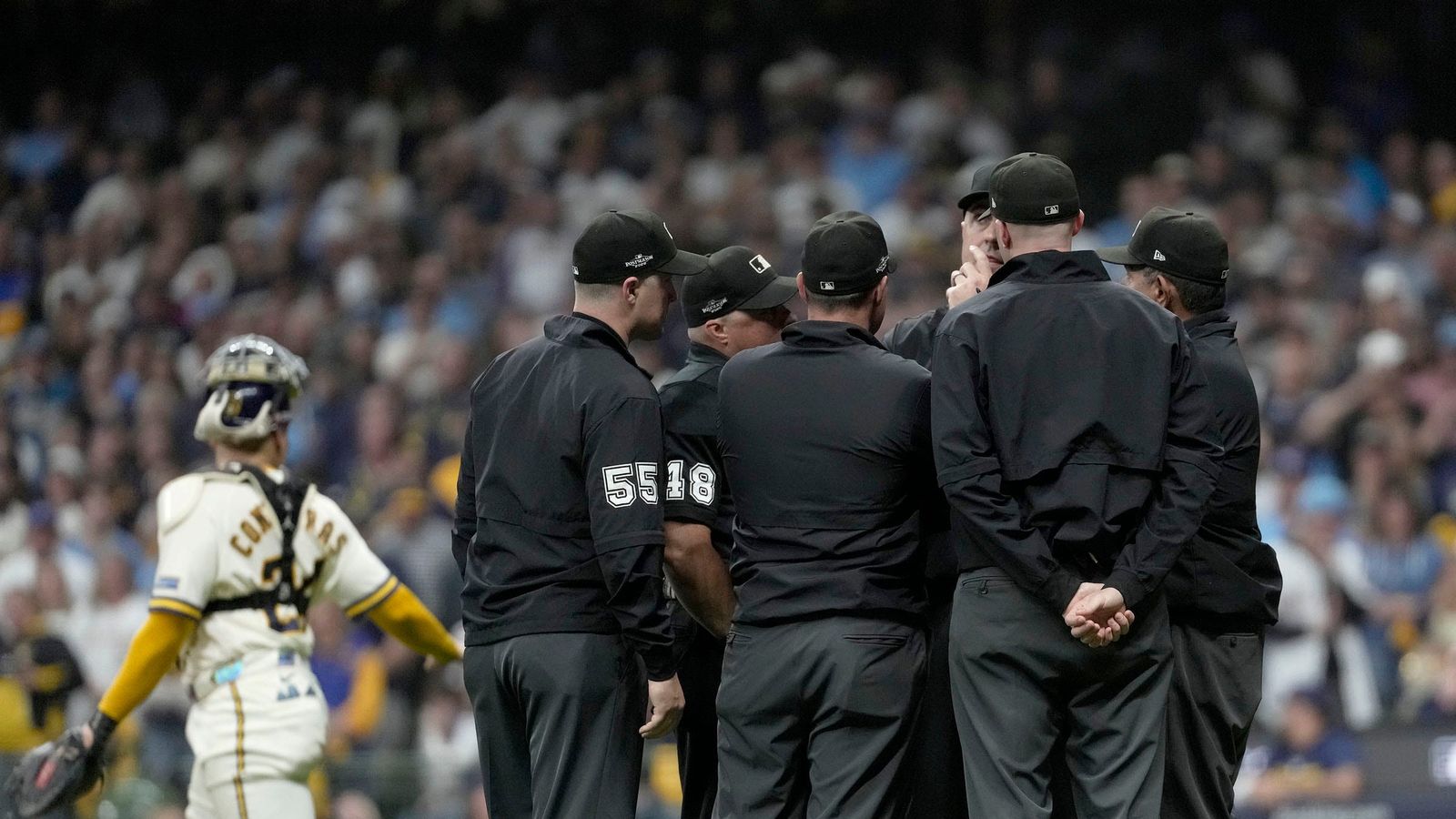 Umpires meet to discuss the fly ball hit by San Diego Padres first baseman Ty France (25) that hit a wire during the ninth inning of their National League Division Series game against the Milwaukee Brewers at American Family Field on Oct 3, 2026. Umpires meet to discuss the fly ball hit by San Diego Padres first baseman Ty France (25) that hit a wire during the ninth inning of their National League Division Series game against the Milwaukee Brewers at American Family Field on Oct 3, 2026.